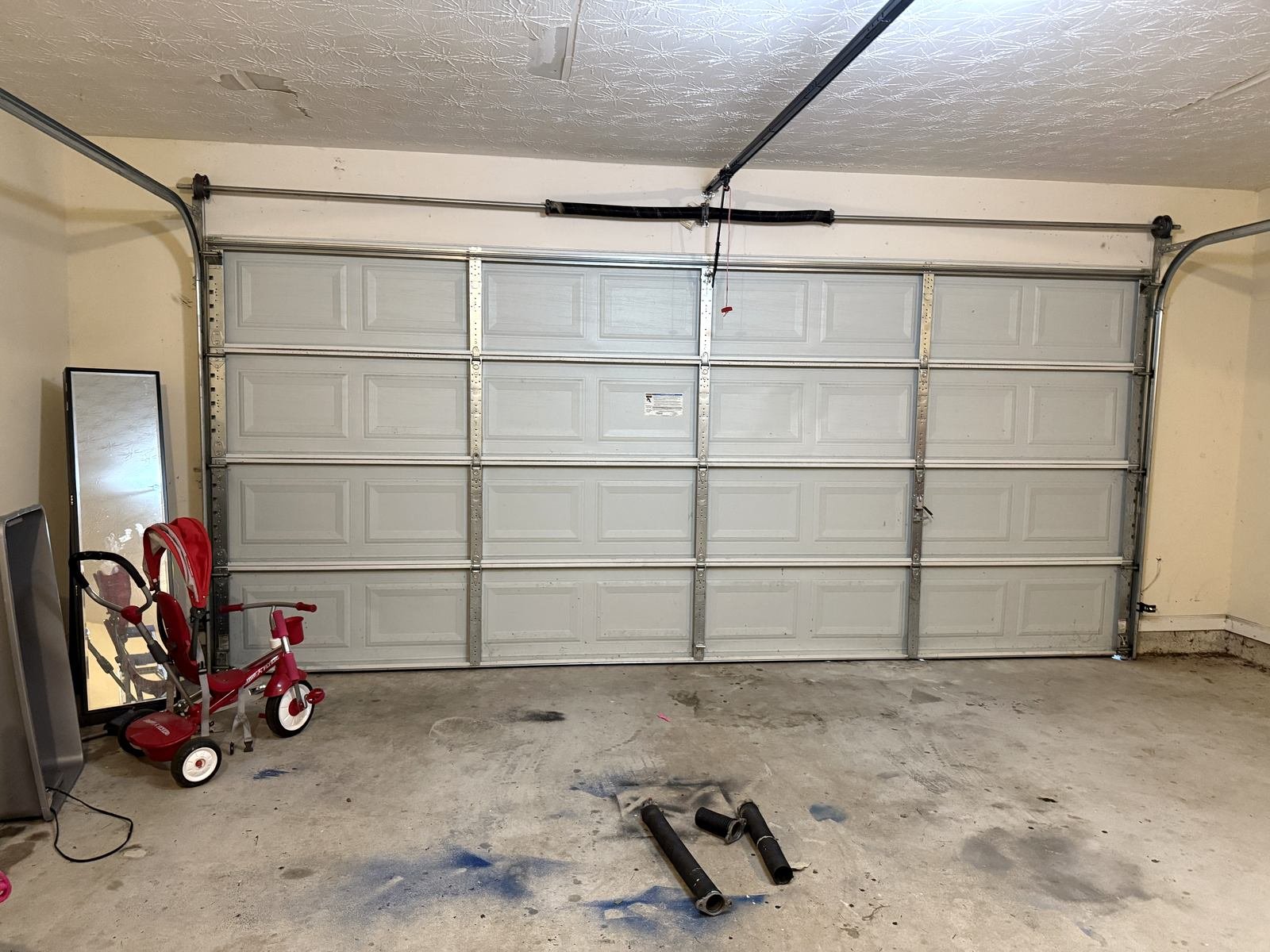 Double garage door in Chamblee, GA after spring replacement with the old broken springs on the floor