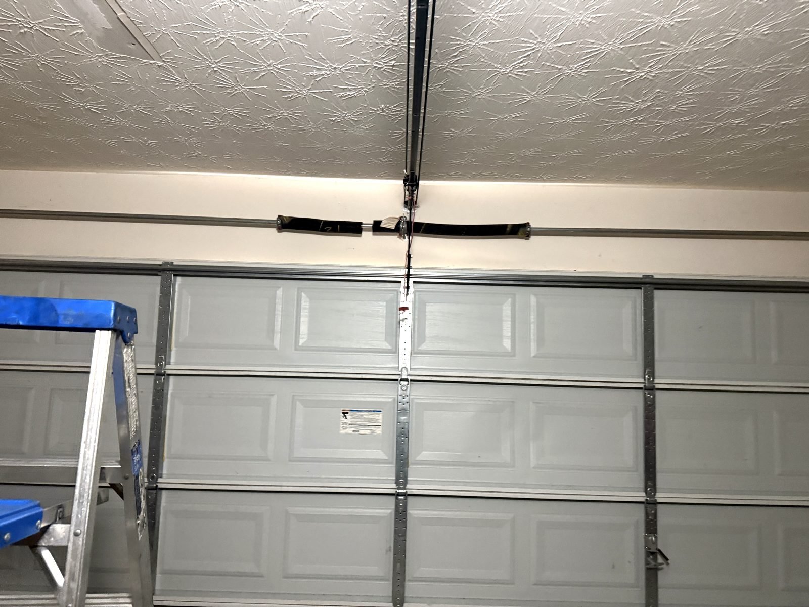 New torsion springs mounted on the shaft above a sectional garage door in Chamblee, GA